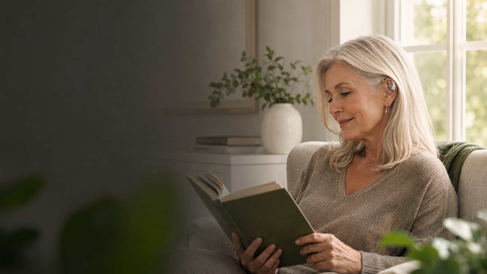 Woman relaxing with a book while wearing a Vitaliva hearing aid